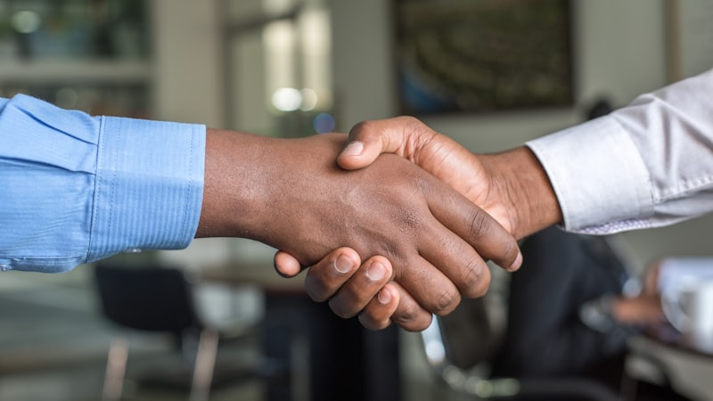 A business handshake in an office, representing employment and gratuity benefits
